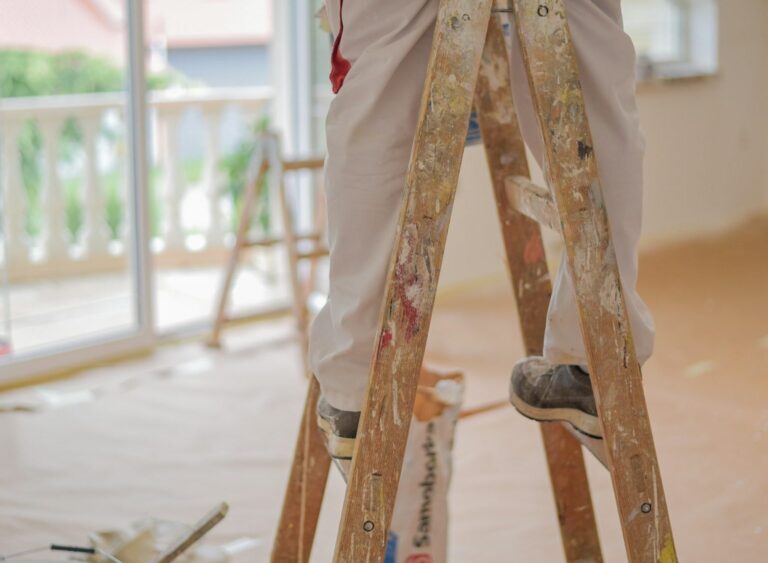 Closeup shot of a painter handyman standing on a ladder